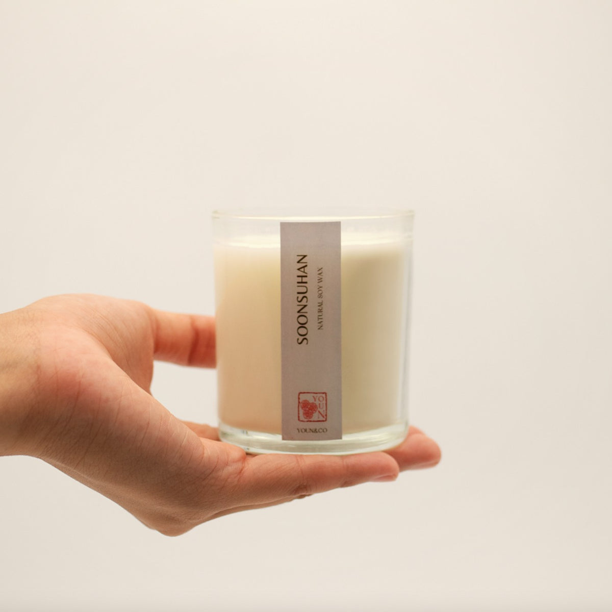Soonsuhan candle held in one hand, showing its size