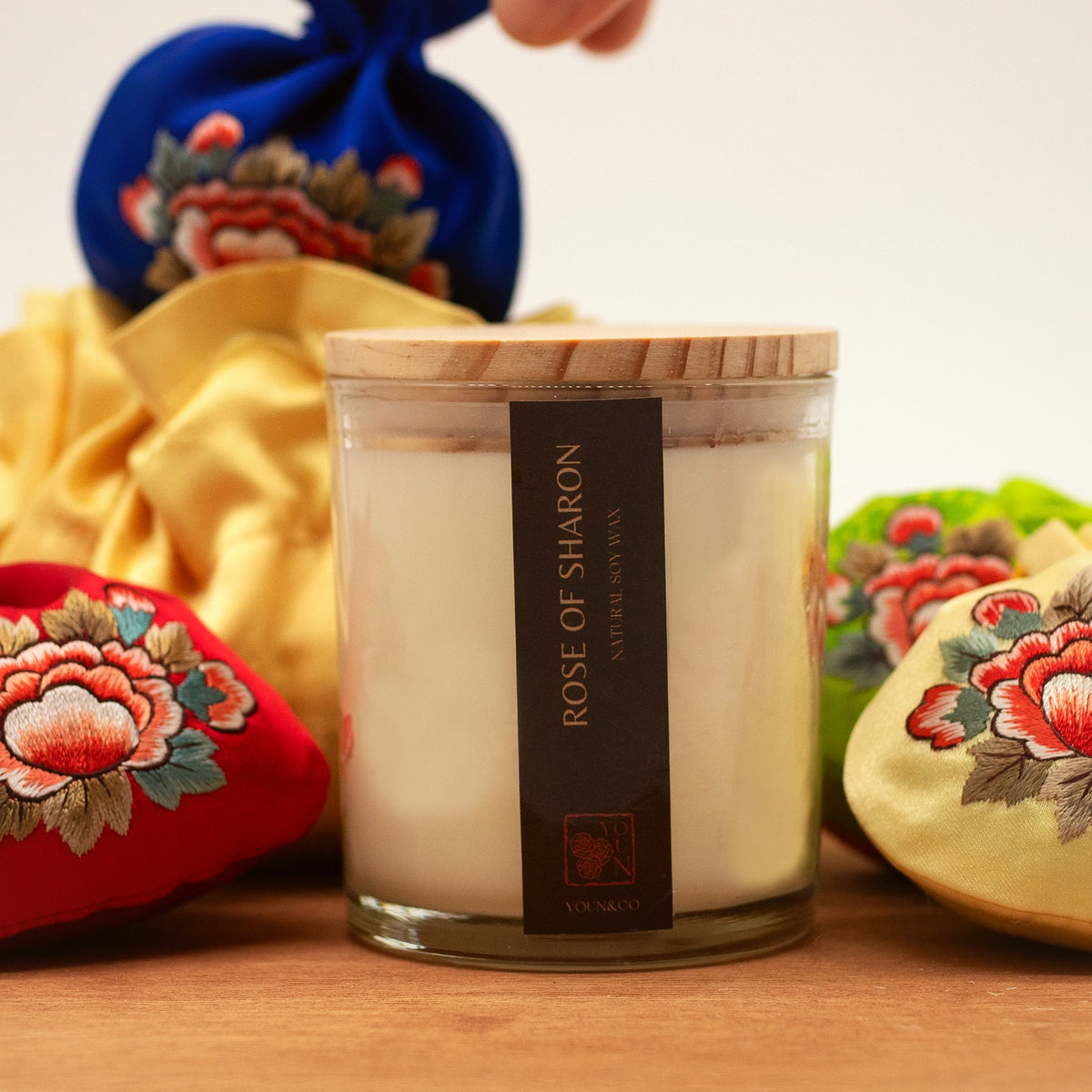 Rose of Sharon candle among embroidered Korean silk pouches